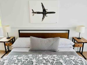 a bedroom with a bed with a plane hanging on the wall at Hamptons Escape: Near Beaches, Restaurants, Wineries. in Hampton Bays