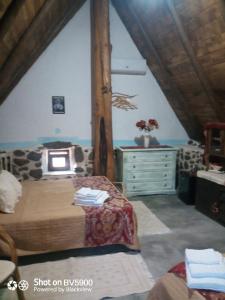 a bedroom with a bed and a dresser in a attic at Ovile Juanne Loddo in Orosei