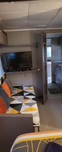 a room with a bed with a tv on it at La Caravane LE NID DOUILLET in Ponte-Leccia +17 photos
