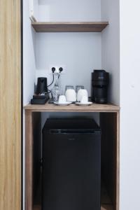 un piccolo frigorifero nero sotto un tavolo di legno di Uphill Unique Boutique Suites a Città di Skiathos