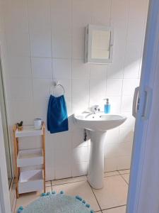 a white bathroom with a sink and a blue bag at 4 Boboyi - Mangrove Beach Estate in Port Shepstone