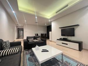 a living room with a couch and a tv at White Luxury Suite Hotel in Kuwait
