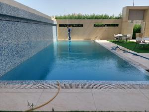 a man is standing in a swimming pool at White Luxury Suite Hotel in Kuwait