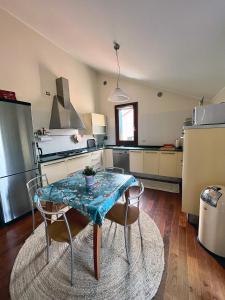 a kitchen with a table and two chairs and a kitchen with a refrigerator at Nido Appartamento in Cavallino-Treporti