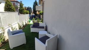 patio con sedie bianche e recinzione bianca di Casa Vacanze "Machí" a Senigallia