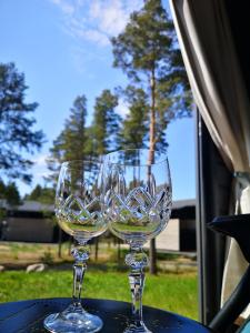 two wine glasses sitting on top of a table at Northern Lights - Cozy apartment, sisältää liinavaatteet in Kalajoki