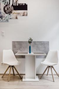 duas cadeiras brancas e uma mesa num quarto em Elegant Studio in Central Budapest em Budapeste