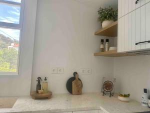uma cozinha com um balcão com vasos na parede em The Bower - Volos FREE DIVING LESSON em Marathos