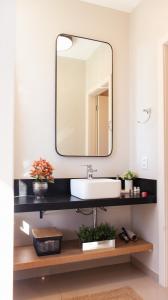 La salle de bains est pourvue d'un lavabo et d'un miroir. dans l'établissement Super TinyHouse ao Lado da Igreja Matriz, à Urubici