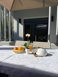 uma mesa com um prato de frutas e uma taça de laranjas em Casa com jardim perto da praia em Sesimbra
