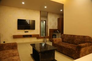 a living room with two couches and a flat screen tv at HOTEL HOLISTON in Dwarka