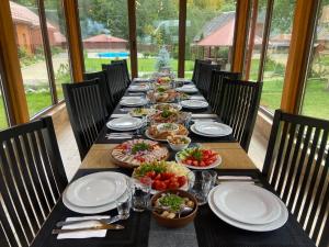 un lungo tavolo con piatti e ciotole di cibo sopra di Перлина Лумшор a Lumshory