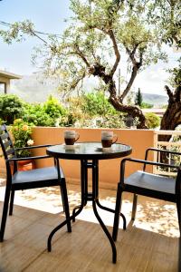 een tafel en 2 stoelen op een patio bij ADONIOS APARTMENTS in Archangelos