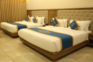 two beds in a hotel room with two bedsvisor at HOTEL HOLISTON in Dwarka