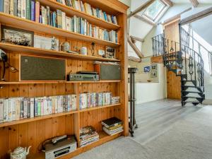 a book shelf filled with books next to a staircase at Mill Barn in Askham