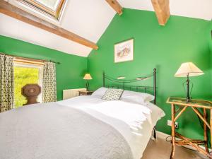 a green bedroom with a bed and a green wall at Mill Barn in Askham