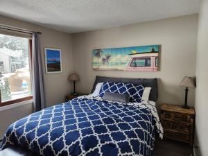 a bedroom with a blue and white bed and a window at Caribbean Club Resort in Wisconsin Dells