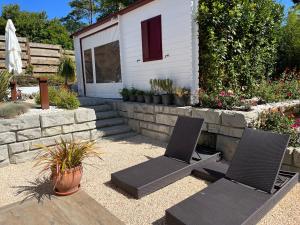 eine Terrasse mit 2 Stühlen und ein Haus in der Unterkunft Le 7 in Capbreton