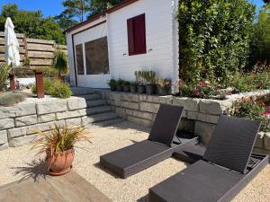 een patio met 2 stoelen en een huis bij Le 7 in Capbreton