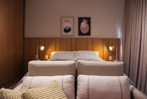 two twin beds in a hotel room with two pillows at Super TinyHouse ao Lado da Igreja Matriz in Urubici