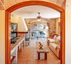 cocina y sala de estar con pared de piedra en Mas dels Avis Tipica Masia Catalana en Vall-Llobrega