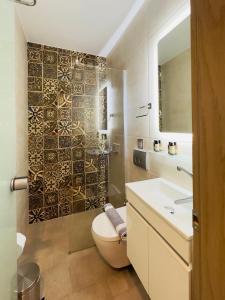 bagno con servizi igienici, lavandino e specchio di Yulia Luxury Apartment a Ouranoupoli