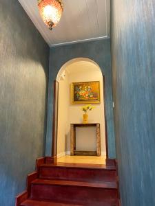 a hallway with stairs with a mirror and a painting at Mimoza Guesthouse in Istanbul