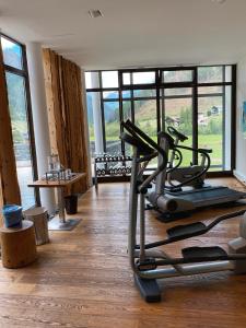 a gym with a treadmill in front of a large window at Spa Hotel Zedern Klang in Hopfgarten in Defereggen