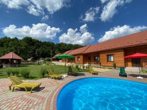 a swimming pool with chairs and a house at Перлина Лумшор in Lumshory