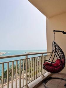 a chair sitting on a balcony looking out at the ocean at Nazeel - Sea view Marina Apt in King Abdullah Economic City