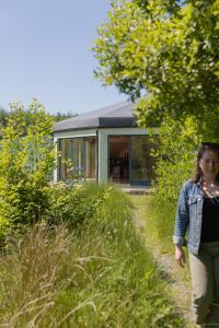 a woman walking down a path in front of a house at The Common Knowledge Centre in Kilfenora