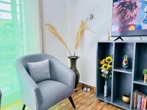 ein Wohnzimmer mit einem Stuhl und einer Vase mit Blumen in der Unterkunft Apartment unit-White house with Two bedrooms in Bulindo
