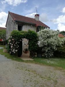 una casa vieja con un ramo de flores en Gîte du mont de transet en Thauron