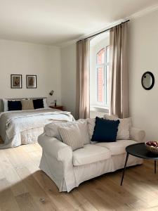 sala de estar con sofá blanco y cama en Lawenda Apartamenty Boutique, en Kudowa-Zdrój