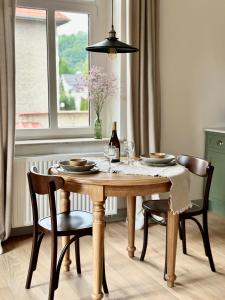 a dining room table with two chairs and a wine glass at Lawenda Apartamenty Boutique in Kudowa-Zdrój +81 photos