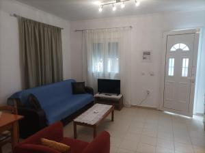 un soggiorno con divano blu e tavolo di GEORGECHRISTI HOUSE a Skala Kallirachis