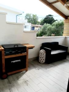een patio met een fornuis, een bank en een tafel bij L'appartamento sul borgo in Santa Lucia