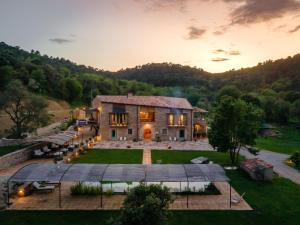 an aerial view of a house with a sunset at ECOTurisme Can Buch HOTEL in Sant Aniol de Finestras