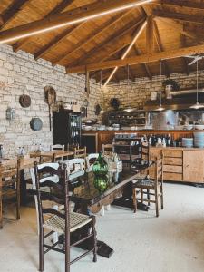 a dining room with a wooden table and chairs at ELÉA Guesthouse himare in Himare