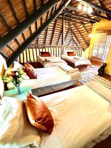 a room with three beds with a vase of flowers at Kruger River View in Marloth Park