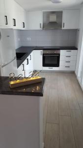 a kitchen with white cabinets and a black counter top at Kerasies Studios in Patitiri