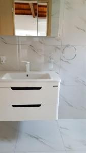 a white bathroom with a sink and a mirror at Kerasies Studios in Patitiri