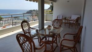 a table and chairs on a balcony with a view of the ocean at Kerasies Studios in Patitiri