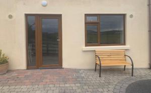 un banco sentado frente a un edificio con ventana en Ard Locha - Lake View Apartment, 