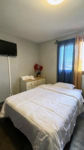 Un dormitorio con una gran cama blanca y una ventana en Cozy Private Room With Two Beds, en Anchorage