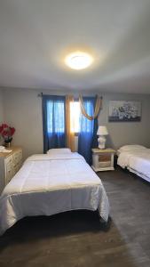 a bedroom with two beds and blue curtains at Cozy Private Room With Two Beds in Anchorage
