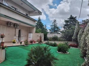 a yard with a green lawn in front of a house at Casa di Tina in Castellana Grotte