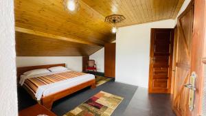 a bedroom with a bed and a wooden ceiling at Denis House 1930 Cozy Private Rooms with Authentic Charm in Gjirokastër