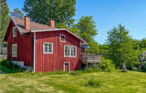 ein rotes Haus mit einer Terrasse im Hof in der Unterkunft Stunning Home In Ydre With Kitchen 