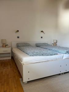 sypialnia z 2 łóżkami i białą ścianą w obiekcie Apartment in Ljubljana w Lublanie
